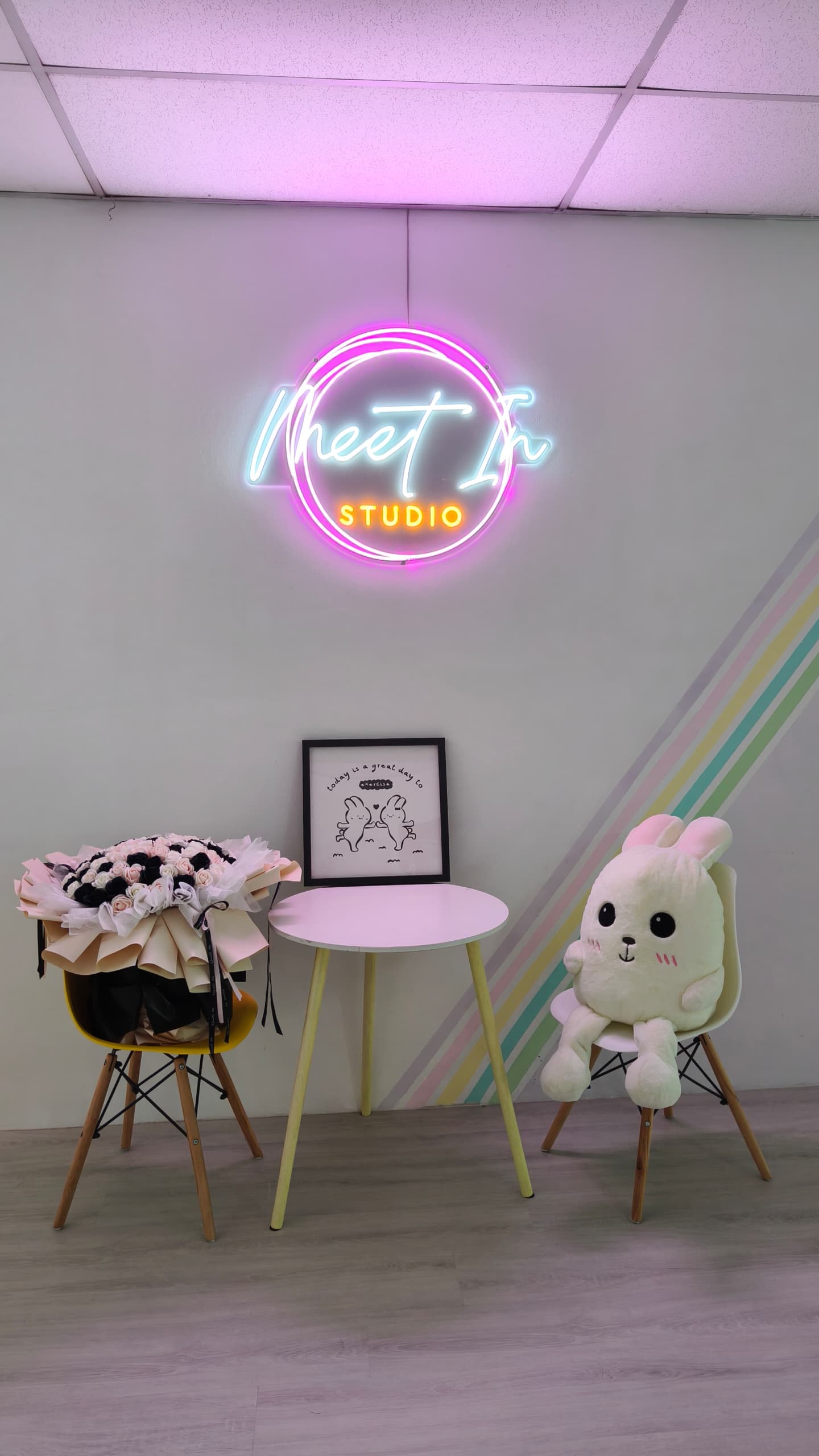 Meet In Studio entrance — neon logo sign, pastel rainbow wall, welcoming lobby in Kuala Lumpur dance fitness studio