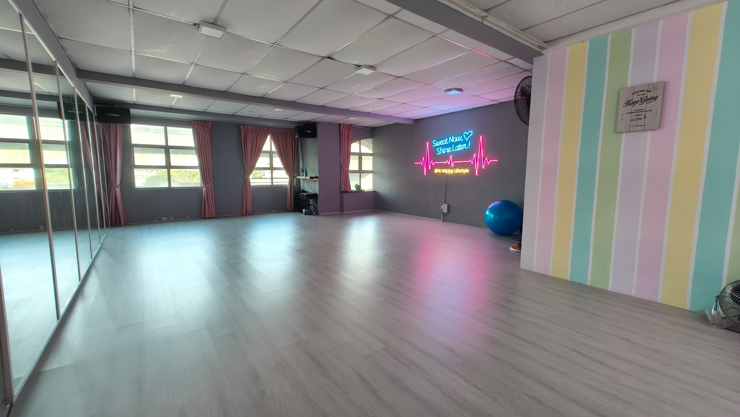 Full panorama of Meet In Studio — mirrors, neon sign, pastel rainbow wall, spacious dance floor in KL